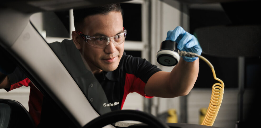 Safelite technician repairing a chip in a windshield